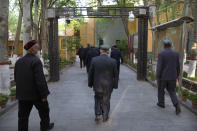 Uyghurs and other members of the faithful walk under an arch with security cameras as they leave after prayers at the Id Kah Mosque in Kashgar in western China's Xinjiang Uyghur Autonomous Region, as seen during a government organized trip for foreign journalists, Monday, April 19, 2021. A human rights group is appealing to the United Nations to investigate allegations China's government is committing crimes against humanity in the Xinjiang region. Human Rights Watch cited reports of the mass detention of Muslims, a crackdown on religious practices and other measures against minorities in the northwestern region. (AP Photo/Mark Schiefelbein)