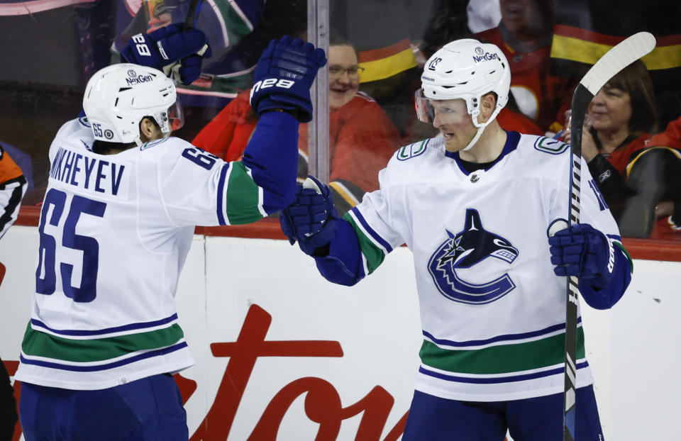 Vancouver Canucks forward Sam Lafferty, right, celebrates his goal with teammate forward Ilya Mikheyev during the first period of an NHL hockey game against the Calgary Flames, Saturday, Dec. 2, 2023 in Calgary, Alberta. (Jeff McIntosh/The Canadian Press via AP)