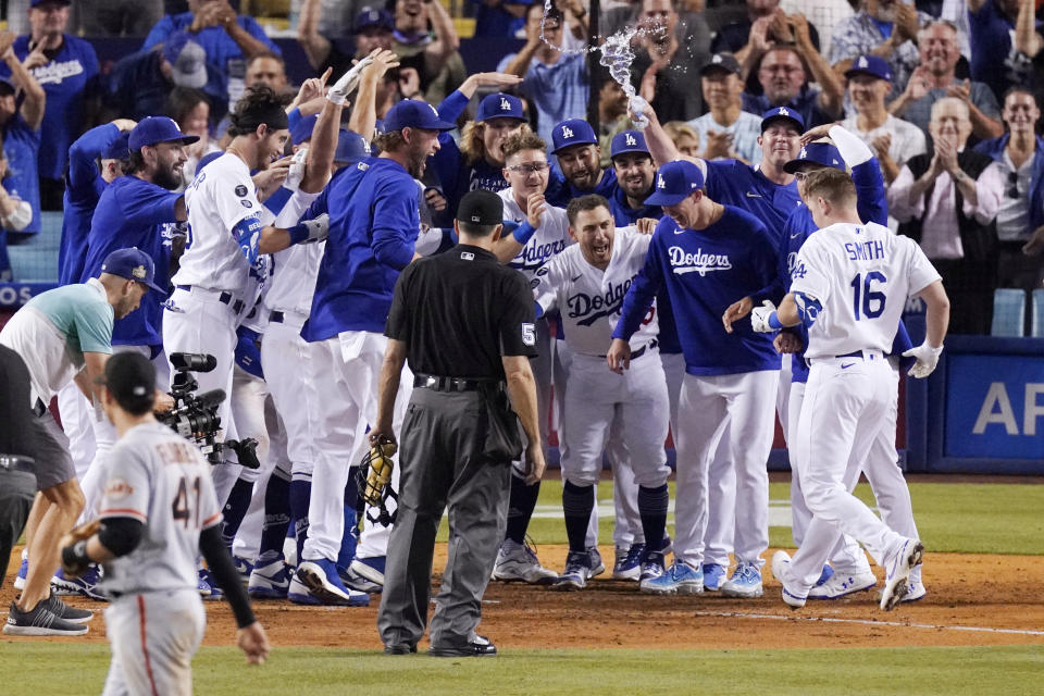 Members of the Los Angeles Dodgers celebrate as Will Smith, right, scores after hitting a three-run walk off home run during the ninth inning of a baseball game against the San Francisco Giants Tuesday, July 20, 2021, in Los Angeles. (AP Photo/Mark J. Terrill)