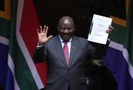 File — South African President Cyril Ramaphosa shows the signed bill for National Health Insurance signed into law in Pretoria, South Africa, Wednesday, May 15, 2024. Today the ruling African National Congress (ANC) faces growing dissatisfaction from many who feel it has failed to live up to its promises. (AP Photo/The,ba Hadebe-File)