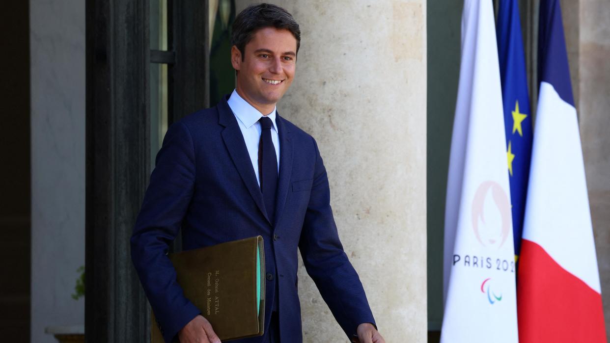 French Prime Minister Gabriel Attal walking carrying a brown folder
