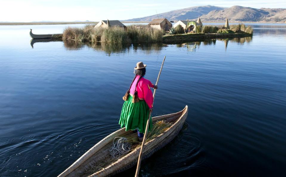 Local woman steers her canoe across Lake Titicaca - Getty