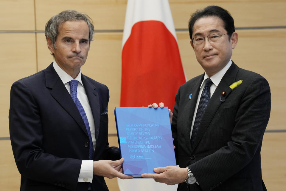 Rafael Mariano Grossi, Director General of the International Atomic Energy Agency, left, presents IAEA's comprehensive report on Fukushima Treated Water Release to Japanese Prime Minister Fumio Kishida, right, at the prime minister's office Tuesday, July 4, 2023 in Tokyo. (AP Photo/Eugene Hoshiko, Pool)