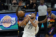 Utah Jazz center Rudy Gobert (27) loses the ball as Phoenix Suns center Deandre Ayton defends during the first half of an NBA basketball game, Wednesday, April 7, 2021, in Phoenix. (AP Photo/Matt York)