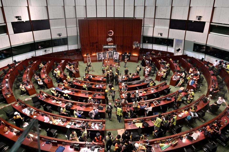 Protesters and members of the media are seen in the parliament chambers after protesters broke into the government headquarters in Hong Kong on July 1, 2019, on the 22nd anniversary of the city's handover from Britain to China. - Hundreds of protesters stormed Hong Kong's parliament late on July 1 as the territory marked its China handover anniversary, ransacking the building and daubing its walls with graffiti as the city plunged into unprecedented depths of political chaos. (Photo by Anthony WALLACE / AFP)        (Photo credit should read ANTHONY WALLACE/AFP/Getty Images)