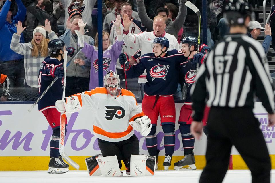 Nov 15, 2022; Columbus, Ohio, USA;  Columbus Blue Jackets right wing Yegor Chinakhov (59) and center Cole Sillinger (34) celebrate the game-winning goal by defenseman Vladislav Gavrikov (4) behind Philadelphia Flyers goaltender Carter Hart (79) during overtime of the NHL hockey game at Nationwide Arena. The Blue Jackets won 5-4. Mandatory Credit: Adam Cairns-The Columbus Dispatch