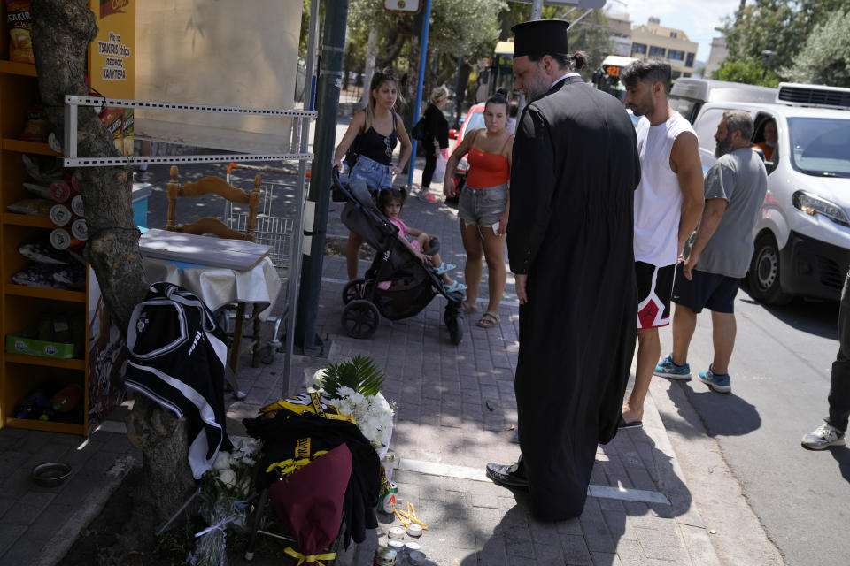 People gather at the location where a 29-year-old Greek fan has died after overnight clashes between rival supporters in Nea Philadelphia suburb, in Athens, Greece, Tuesday, Aug. 8, 2023. European governing soccer body UEFA says it has postponed a Champions League qualifying game between AEK Athens and Croatia's Dinamo Zagreb scheduled for Tuesday because of the violence. Eight fans were injured while Greek police said Tuesday they had made 88 arrests, mostly of Croatian supporters. (AP Photo/Thanassis Stavrakis)