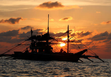 A Philippine boat fishes during sunset at the disputed Scarborough Shoal April 5, 2017. Picture taken April 5, 2017 REUTERS/Erik De Castro