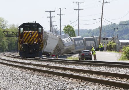 Investigators survey a freight train derailment involving at least 10 cars which left the tracks in Pittsburgh, Pennsylvania May 14, 2015. REUTERS/John Altdorfer