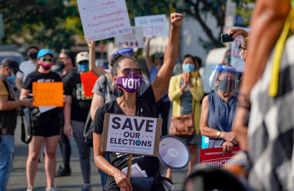 Protesters hold a "Save the Post Office" demonstration outside a United States Postal Service location in Los Angeles, California, on August 22, 2020. - Postmaster General Louis DeJoy on August 21 denied claims he was working to undermine mail delivery, after comments by President Donald Trump raised fears the US Postal Service would be sabotaged to aid his chances in the November elections. (Photo by Kyle Grillot / AFP) (Photo by KYLE GRILLOT/AFP via Getty Images)