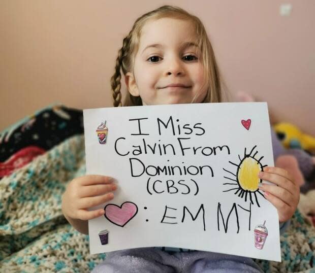 Emmy Laine, 4, holds a sign she made for Calvin Young, who works at the Dominion grocery store in Conception Bay South. (Submitted by Patty Laine - image credit)