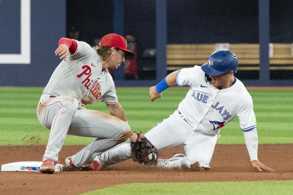 Toronto Blue Jays' Daulton Varsho (25) is tagged out trying to steal second base by Philadelphia Phillies second baseman Bryson Stott (5) during the seventh inning of a baseball game Tuesday, Aug. 15, 2023, in Toronto. (Nathan Denette/The Canadian Press via AP)