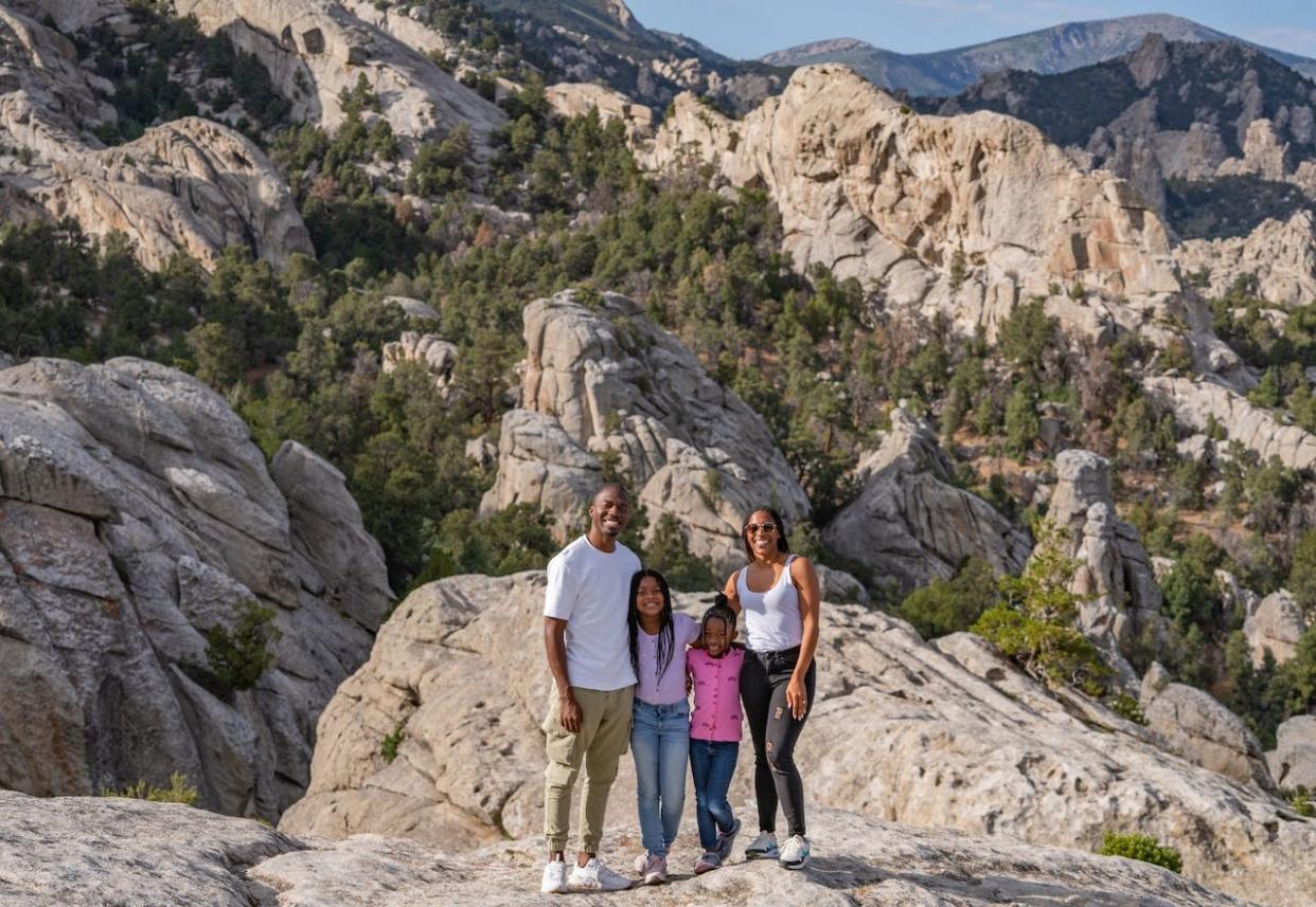 The Hambrick family smile and stand on rocky landscape in Southern Idaho.