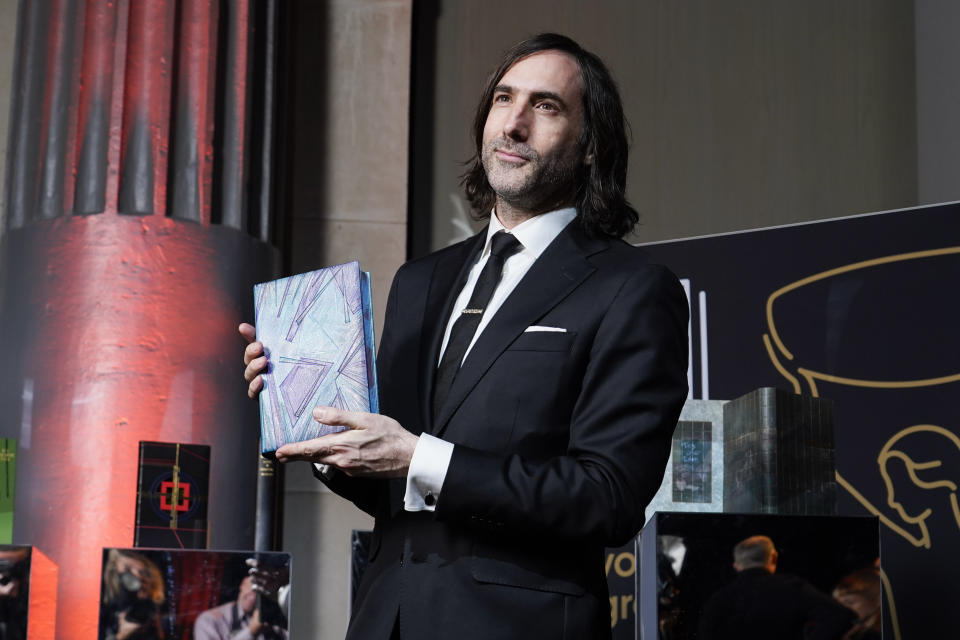 Paul Lynch poses with his book as he arrives at the Booker Prize award dinner, in London, Sunday, Nov. 26, 2023. The Booker Prize is awarded to the best sustained work of fiction written in English and published in the UK and Ireland, in the opinion of the judges. (AP Photo/Alberto Pezzali)