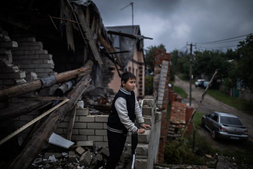 Mykhailo Misha, 9, stands on the ruined roof of his house while he looks at his neighbourhood (Diego Ibarra Sánchez/Unicef)