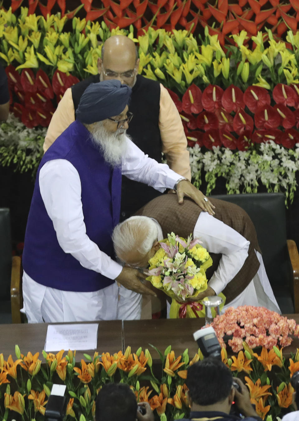 Indian Prime Minister Narendra Modi touches the feet of Akali Dal leader Parkash Singh Badal after being elected Bharatiya Jananta Party and ruling alliance leader, in New Delhi, India, Saturday, May 25, 2019. BJP president Amit Shah announced Modi's name as the leader of the National Democratic Alliance in a meeting of the lawmakers in the Central Hall of Parliament in New Delhi, paving the way for Modi's second five-year term as prime minister after a thunderous victory in national elections. (AP Photo/Manish Swarup)