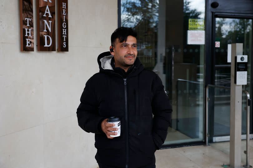 Jaffar Habibi poses for photos in the Grand Heights tower in Slough