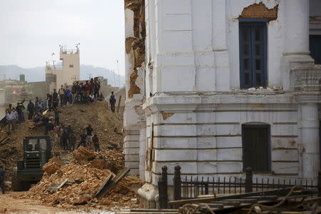 People work to rescue trapped people inside a temple in Bashantapur Durbar Square after an earthquake hit, in Kathmandu