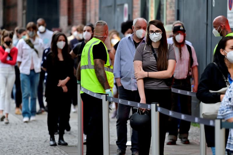 FILE PHOTO: People queue to receive a vaccine against the coronavirus disease (COVID-19) at the Arena Treptow vaccination centre in Berlin