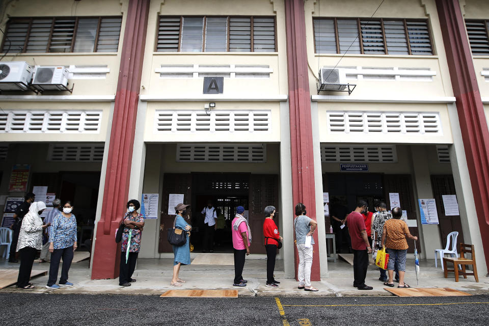 Voters wait in a line to cast their ballots for the general elections at a polling station in Kuala Lumpur, Malaysia, Saturday, Nov. 19, 2022. Malaysians began casting ballots Saturday in a tightly contested national election that will determine whether the country’s longest-ruling coalition can make a comeback after its electoral defeat four years ago. (AP Photo/FL Wong)