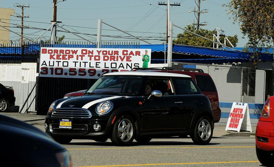 A woman drives past a firm offering cash loans, which use your car as collateral in Los Angeles on Feb. 02, 2011.