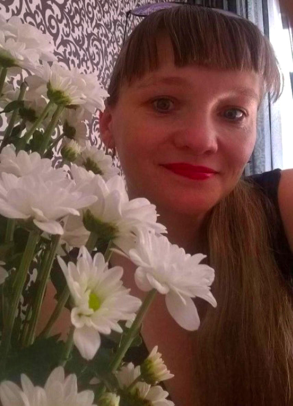 Yulia Zykova is pictured with a bouquet of flowers. She is accused of keeping her unwanted baby in a closet.