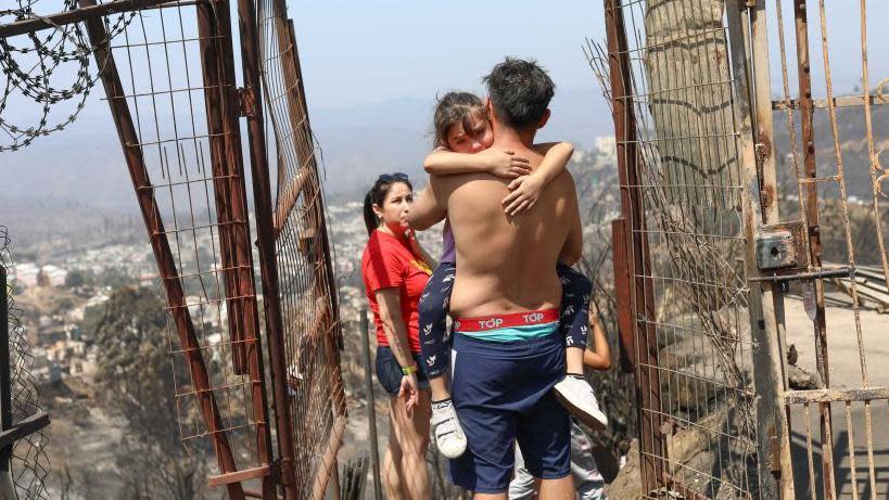 Una familia mira lo que quedó de su casa tras los incendios