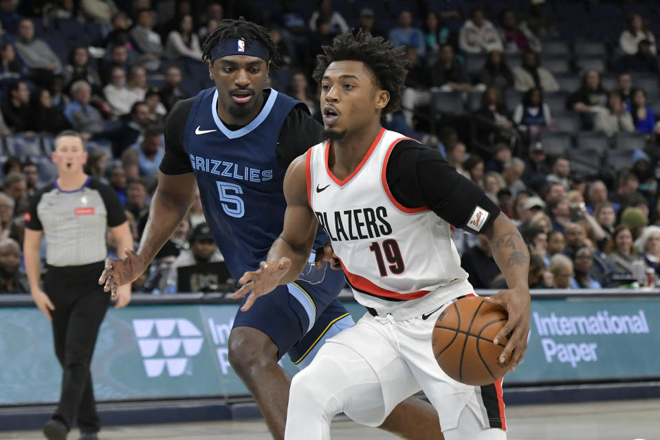 Portland Trail Blazers guard Ashton Hagans (19) handles the ball ahead of Memphis Grizzlies guard Vince Williams Jr. (5) in the first half of an NBA basketball game Friday, March 1, 2024, in Memphis, Tenn. (AP Photo/Brandon Dill)