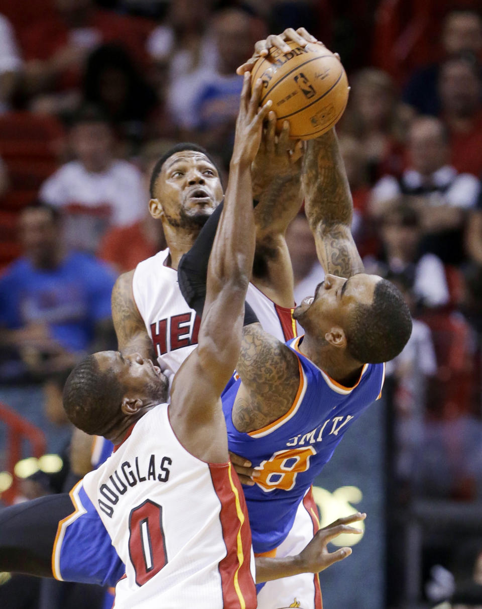 Miami Heat forward Udonis Haslem, rear, and guard Toney Douglas (0) prevent a pass by New York Knicks guard J.R. Smith (8) during the first half of an NBA basketball game, Sunday, April 6, 2014, in Miami. (AP Photo/Wilfredo Lee)
