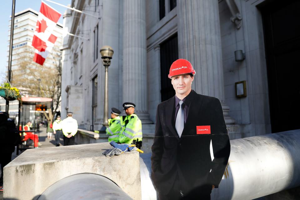 A cardboard cut-out of Canada's Prime Minister Justin Trudeau is pictured as demonstrators use a mock oil pipeline to block the entrance to the Canadian Embassy in central London on April 18, 2018. (Photo credit should read TOLGA AKMEN/AFP/Getty Images)