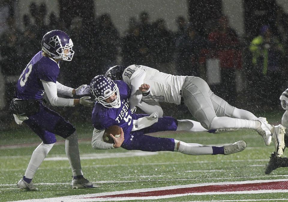 Pickerington Central's Braden Mantooth is hit by Pickerington North's David Alabi as Central's Dominic Shaw, left, runs in during a Division I regional semifinal game at Newark's White Field on Nov. 12, 2021.