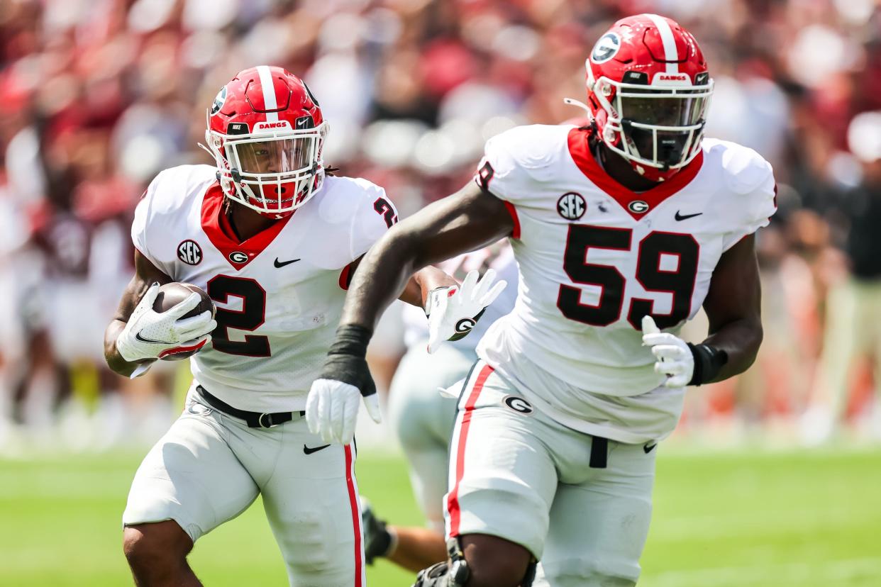 Sep 17, 2022; Columbia, South Carolina, USA; Georgia Bulldogs running back Kendall Milton (2) rushes behind the blocking of Georgia Bulldogs offensive lineman Broderick Jones (59) in the first quarter at Williams-Brice Stadium. Jeff Blake-USA TODAY Sports