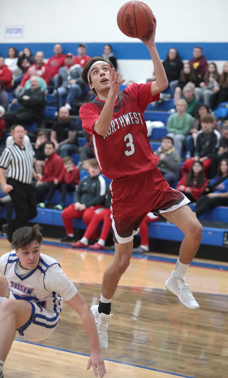 Northwest's Aidan Barna goes to the hoop on a fast break with defense from Tuslaw's Max McMerrell in the second half at Tuslaw Friday, January 21, 2022.