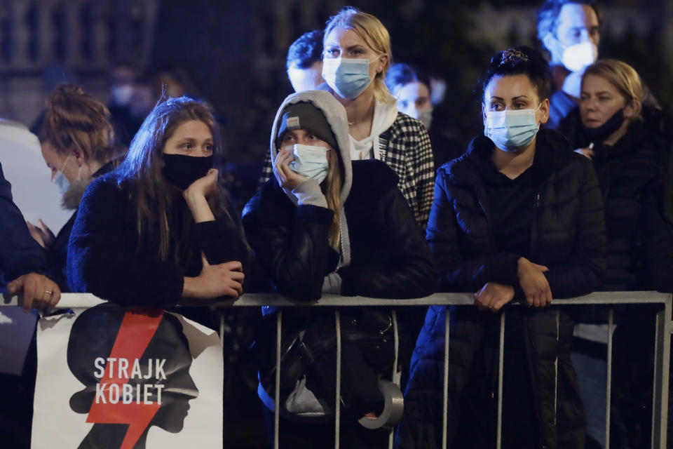 A crowd defying pandemic-related ban on gatherings protests outside the house of Poland's ruling conservative party leader Jaroslaw Kaczynski against a decision by the Constitutional Court, in Warsaw, Poland, on Friday, Oct. 23, 2020. Poland’s top court ruled Thursday that a law allowing abortion of fetuses with congenital defects is unconstitutional, shutting a major loophole in the predominantly Catholic country's abortion laws that are among the strictest in Europe. Blocked by the police, the protesters chanted for the government to resign. (AP Photo/Czarek Sokolowski)