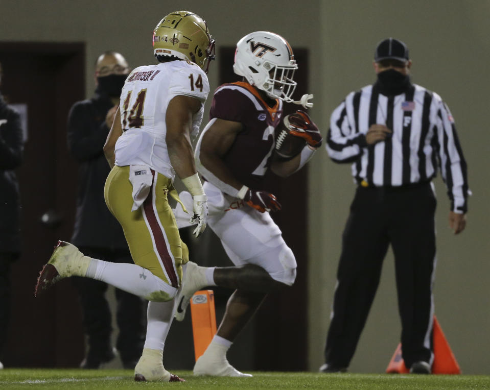 Khalil Herbert, right, of Virginia Tech scores past Sam Johnson III of Boston College in the first half of an NCAA college football game in Blacksburg, Va. Saturday, Oct. 17, 2020. (Matt Gentry/The Roanoke Times via AP, Pool)