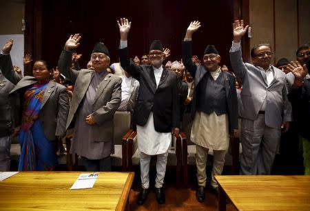 Nepal's Prime Minister Sushil Koirala (C), along with chairman of the Unified Communist Party of Nepal (Maoist) Pushpa Kamal Dahal, also known as Prachanda (R), chairman of the Communist Party of Nepal (Unified Marxist-Leninist) (CPN-UML) Khadga Prashad Oli, also known as KP Oli (2nd R), and Nepalese Constituent Assembly chairperson Subash Chandra Nemwang (2nd L), waves toward media personnel after signing the copy of constitution at the parliament in Kathmandu, Nepal September 18, 2015. REUTERS/Navesh Chitrakar
