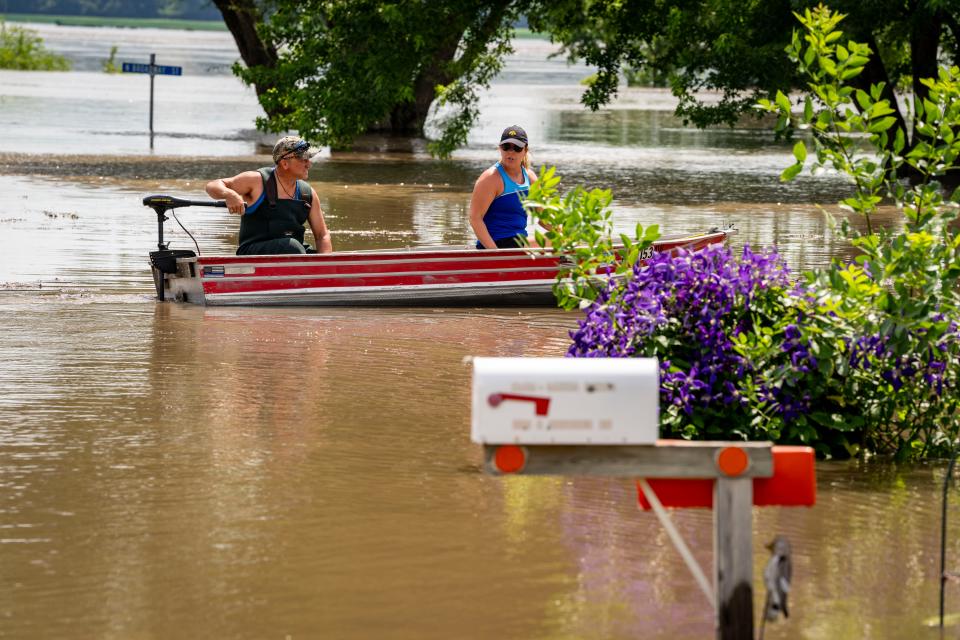 Jason Carlson and wife, Ann, use a boat to retrieve medications for a relative as the Little Sioux River floods homes in Smithland, Tuesday, June 25, 2024.