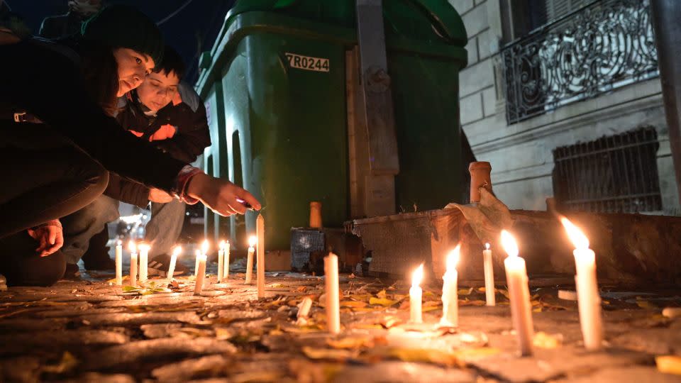 Women light candles during a vigil in front of the boarding house where two lesbians were killed in Buenos Aires on May 8, 2024. - Juan Mabromata/AFP/Getty Images