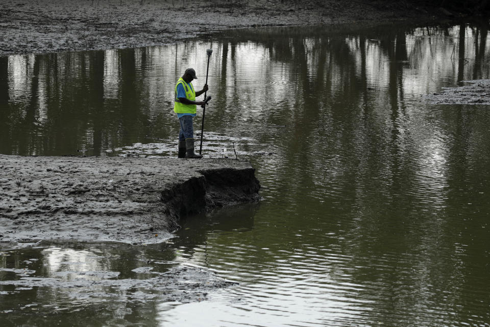 FILE - In this Aug. 6, 2019, file photo, U.S. Army Corps of Engineers worker Ron Allen uses a GPS tool to survey the extent of damage where a levee failed along the Missouri River near Saline City, Mo. The National Weather Service said Thursday, Feb. 13, 2020, there is an elevated flood risk along the eastern Missouri River basin this spring because the soil remains wet and significant snow is on the ground in North Dakota and South Dakota. (AP Photo/Charlie Riedel, File)