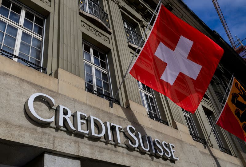 FILE PHOTO: A Swiss flag is pictured above a logo of Swiss bank Credit Suisse in Bern