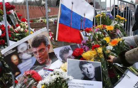 People lay down flowers at the site, where Kremlin critic Boris Nemtsov was murdered on Friday night, during a march to commemorate him in central Moscow March 1, 2015. REUTERS/Tatyana Makeyeva