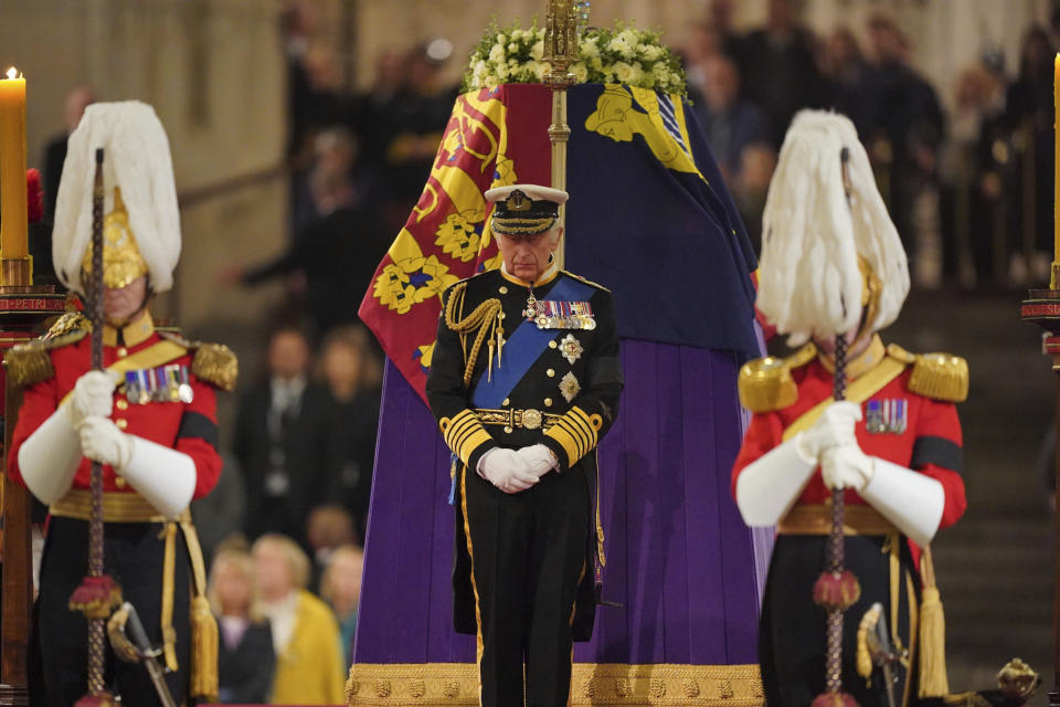 ARCHIVO – El rey Carlos III hace una vigilia junto al féretro de la reina Isabel II durante sus honores de Estado de cuerpo presente en el catafalco en el Salón Westminster en el Palacio de Westminster, en Londres el viernes 16 de septiembre de 2022. Cuando murió el abuelo de la reina Isabel II, el rey Jorge V, la vida en Gran Bretaña era completamente diferente en 1936. Pero a pesar de casi un siglo de cambios, las imágenes de los honores de Estado de cuerpo presente de la reina son casi copias exactas de los de Jorge V. (Dominic Lipinski/Pool Photo via AP)