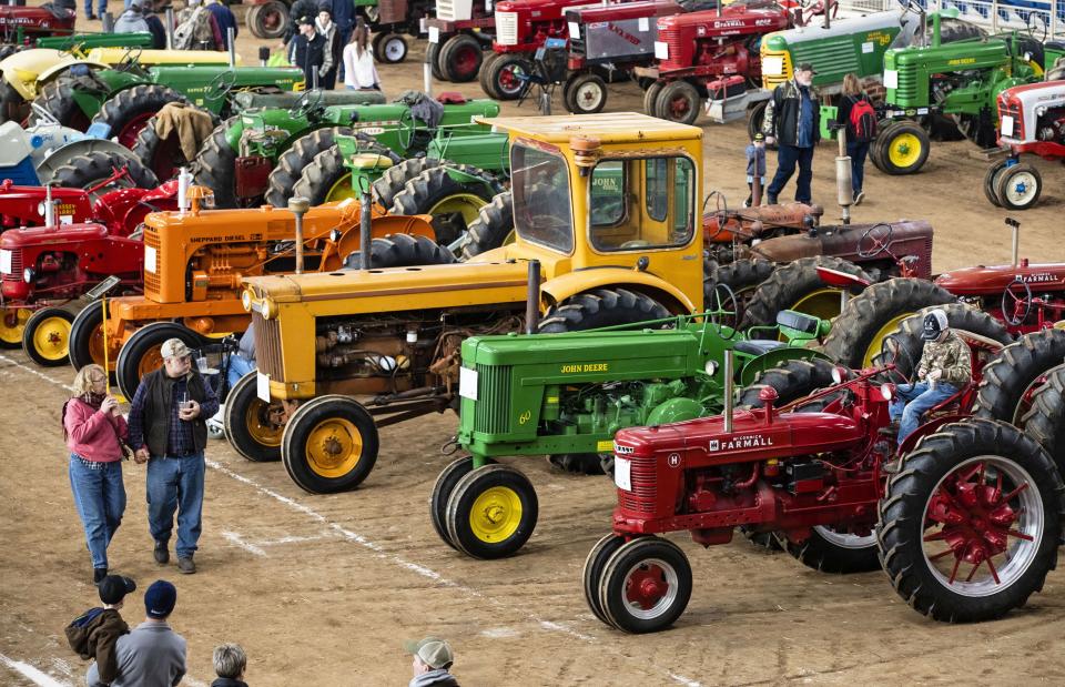 In this Jan. 8, 2020 file photo visitors view antique tractors during the 104th Pennsylvania Farm Show in Harrisburg, Pa. The massive annual Pennsylvania Farm Show was canceled as an in-person event on Wednesday, Aug. 19, 2020 because of the pandemic, ending the prospect of hundreds of thousands of people converging on the Harrisburg complex in January. 