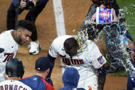 Minnesota Twins' Miguel Sano gets bubble gum poured on him following his walk-off, two-run home run against the Cincinnati Reds in the 12th inning of a baseball game, early Tuesday, June 22, 2021, in Minneapolis. The Twins won 7-5. (AP Photo/Jim Mone)