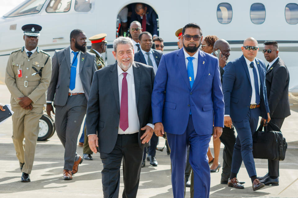 Guyana's President Irfaan Ali, right, walks with St. Vincent and the Grenadines Prime Minister Ralph Gonsalves as Ali arrives to the Argyle International Airport in Argyle, St. Vincent, Thursday, Dec. 14, 2023. Ali arrived for a meeting with Venezuela's President Nicolas Maduro over a long-standing dispute over the Essequibo territory, a vast border region rich in oil and minerals that represents much of Guyana's territory but that Venezuela claims as its own. (AP Photo/Lucanus D. Ollivierre)