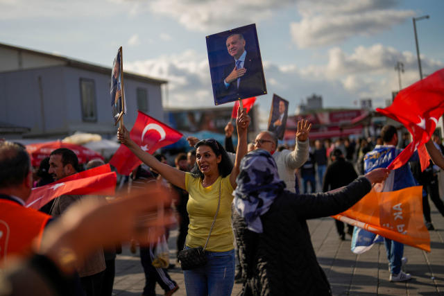 Supporters of Turkish President and People&#x002019;s Alliance&#x002019;s presidential candidate Recep Tayyip Erdogan dance as they give handouts to commuters in Istanbul