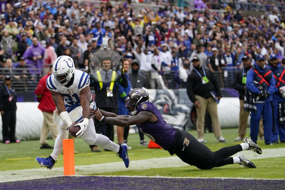 Indianapolis Colts' Zack Moss (21) goes in for a touchdown against Baltimore Ravens' Patrick Queen during the first half of an NFL football game, Sunday, Sept. 24, 2023, in Baltimore. (AP Photo/Julio Cortez)