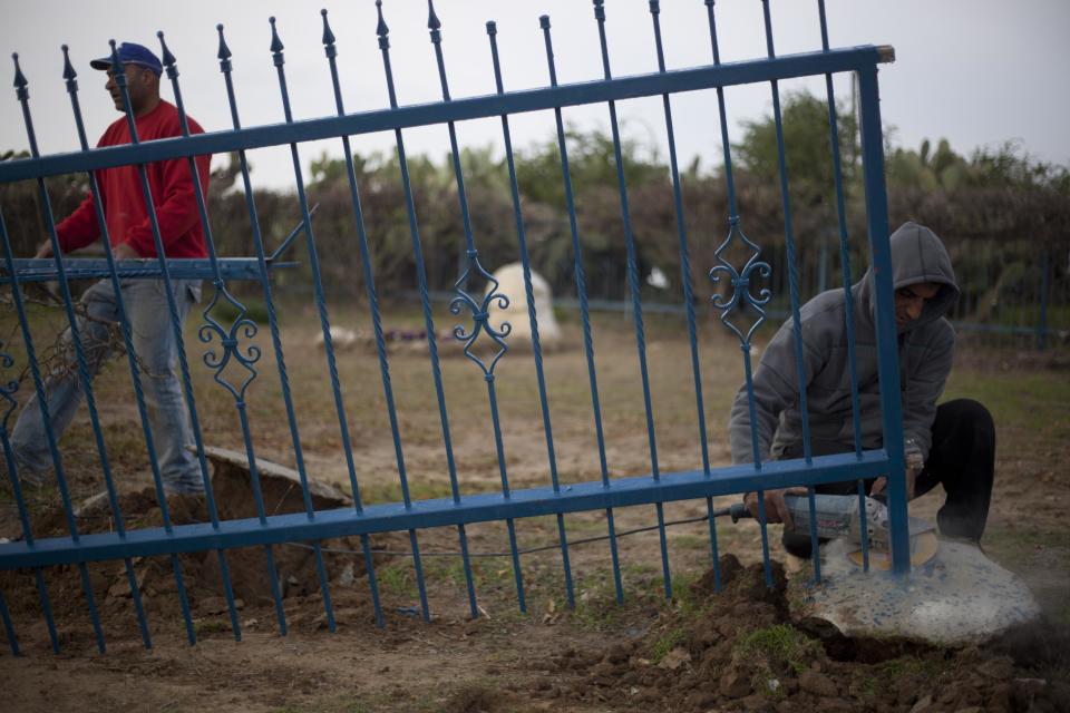 Workers prepare the gravesite for late Israeli Prime Minister Ariel Sharon, who will be buried next to his wife, outside his ranch in Havat Hashikmim, southern Israel, Sunday, Jan. 12, 2014. A state memorial is planned for Monday with the participation of Israeli and world leaders, the prime minister's office said. (AP Photo/Ariel Schalit)