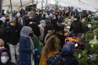 Local residents, most wearing face masks as a preventive measure against the spread of the coronavirus shop in an open market in Istanbul, Wednesday, April 22, 2020 (Wednesday, April 22, 2020. Turkey will start a 4-day curfew declared by Turkey's government in an attempt to control the spread of the COVID-19 pandemic. (AP Photo/Emrah Gurel)