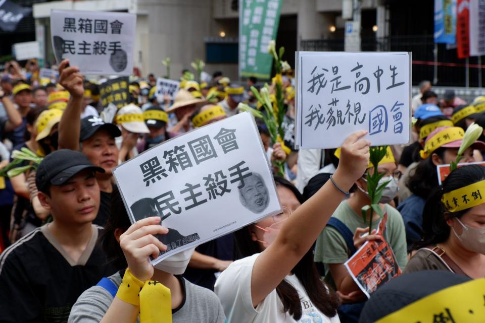 多個民團集結在立法院外，抗議院會續審國會改革法案，參與民眾手舉不同標語。陳祖傑攝